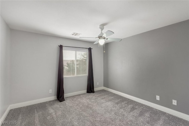 unfurnished room featuring carpet floors, baseboards, visible vents, and ceiling fan