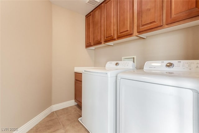 clothes washing area with light tile patterned floors, visible vents, baseboards, independent washer and dryer, and cabinet space