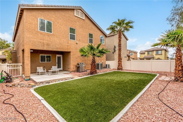 rear view of house with a fenced backyard, a patio, central AC, and stucco siding