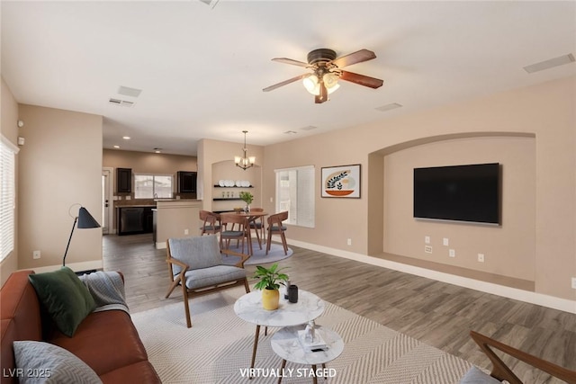 living area featuring recessed lighting, visible vents, wood finished floors, baseboards, and ceiling fan with notable chandelier