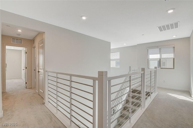 hall featuring recessed lighting, light carpet, visible vents, and an upstairs landing