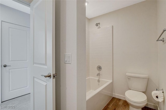 full bath featuring tub / shower combination, wood finished floors, toilet, and baseboards