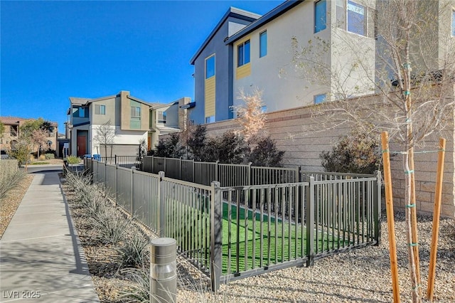 view of home's exterior with a fenced front yard, a residential view, and stucco siding