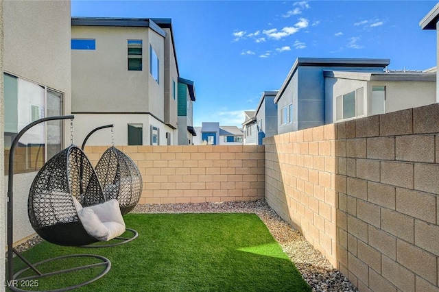 view of yard featuring a fenced backyard and a residential view