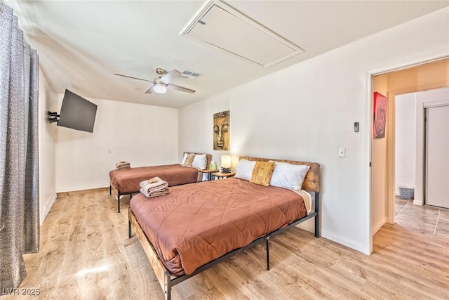 bedroom featuring visible vents, baseboards, ceiling fan, attic access, and light wood-style flooring