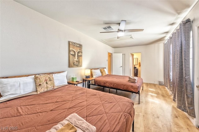 bedroom with a ceiling fan, wood finished floors, and visible vents