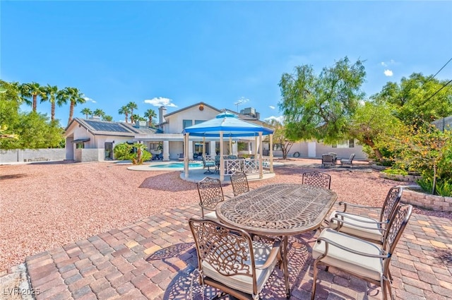 view of patio featuring a gazebo, outdoor dining area, and fence