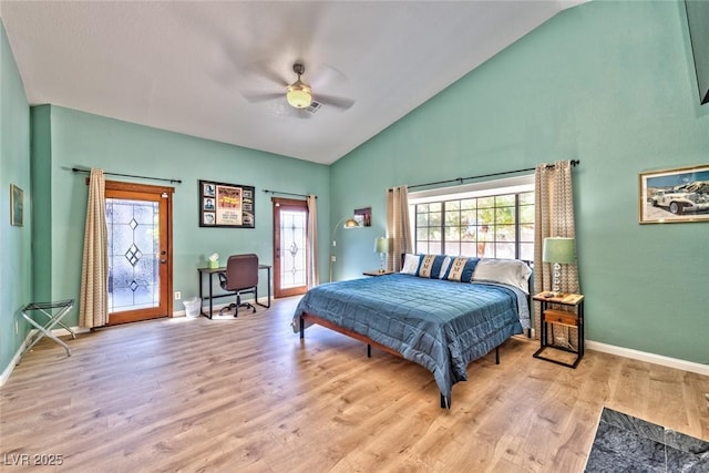 bedroom with baseboards, multiple windows, wood finished floors, and access to outside