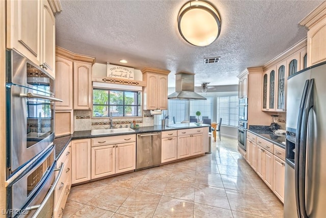 kitchen featuring visible vents, light brown cabinetry, appliances with stainless steel finishes, island range hood, and a sink