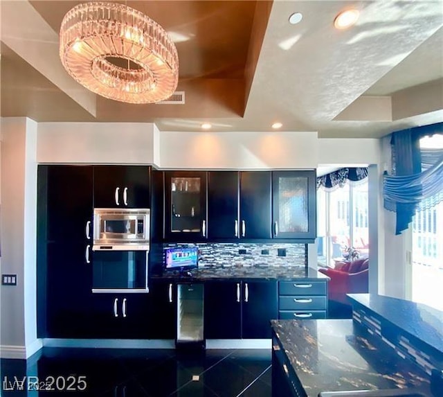 kitchen with recessed lighting, visible vents, appliances with stainless steel finishes, dark stone counters, and glass insert cabinets