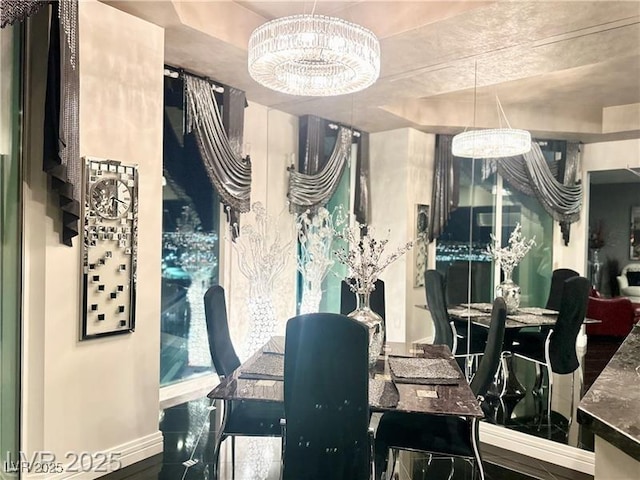 dining room featuring a chandelier and baseboards