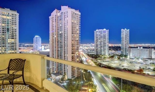 balcony at twilight featuring a view of city lights