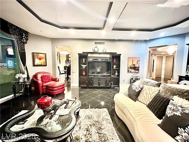 living room featuring dark tile patterned floors, visible vents, and baseboards