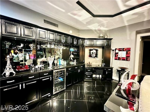 bar featuring a bar, wine cooler, visible vents, and dark tile patterned flooring