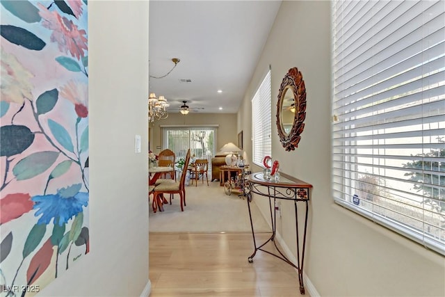 corridor featuring light wood-style flooring, visible vents, and baseboards