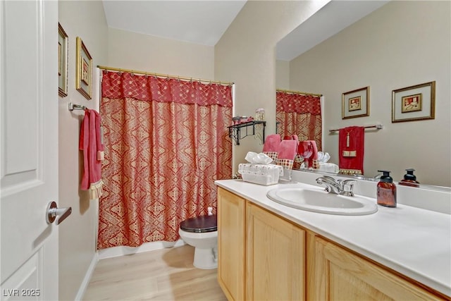 bathroom featuring a shower with shower curtain, vanity, toilet, and wood finished floors