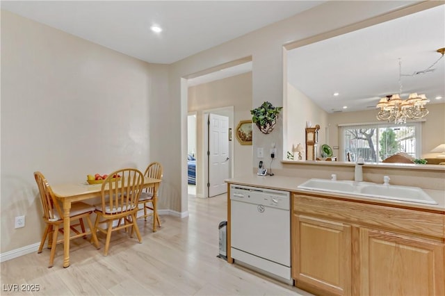 kitchen with a notable chandelier, light countertops, white dishwasher, a sink, and baseboards