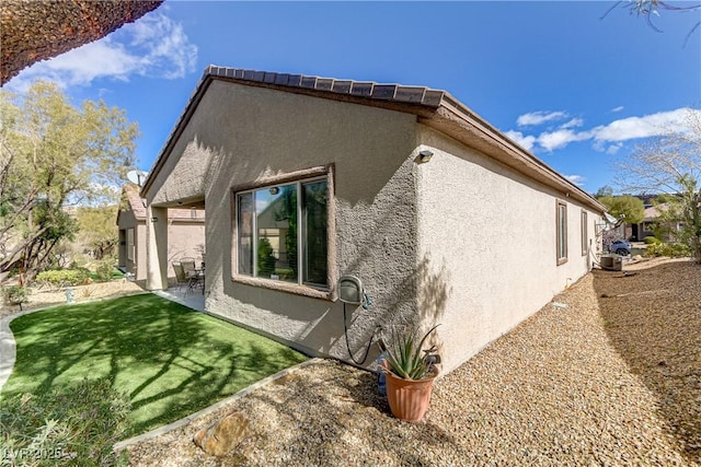 view of property exterior featuring a patio, a yard, and stucco siding