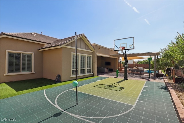 view of basketball court with basketball hoop and fence