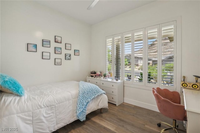 bedroom with a ceiling fan, multiple windows, baseboards, and wood finished floors