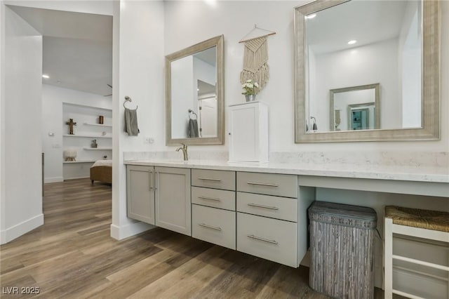 bathroom featuring wood finished floors, vanity, and baseboards