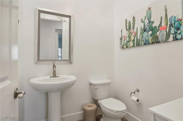 bathroom featuring toilet and baseboards