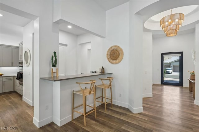 kitchen featuring dark wood-style floors, baseboards, gray cabinets, and an inviting chandelier