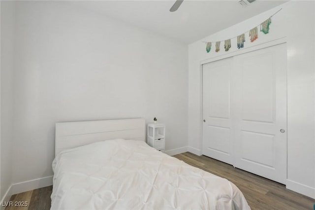 bedroom featuring a ceiling fan, a closet, baseboards, and wood finished floors