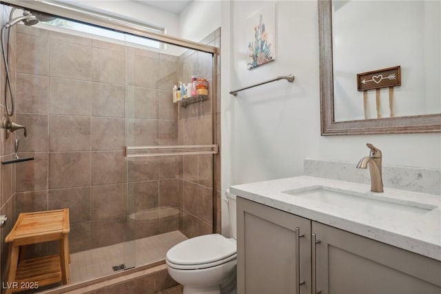 full bath with toilet, a stall shower, and vanity