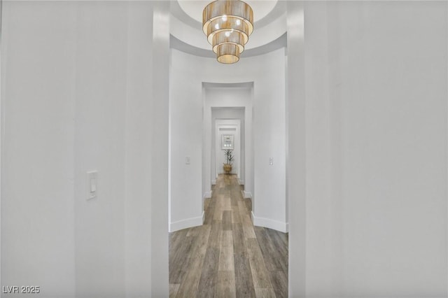 corridor featuring wood finished floors and baseboards