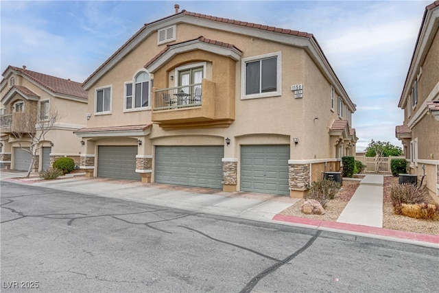 view of front of home featuring stucco siding, an attached garage, a gate, a balcony, and stone siding