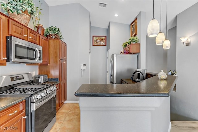 kitchen featuring light tile patterned flooring, stainless steel appliances, visible vents, brown cabinets, and decorative light fixtures