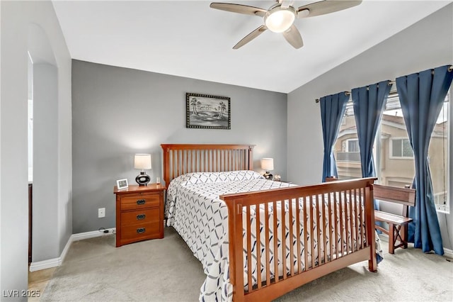 carpeted bedroom featuring baseboards, vaulted ceiling, and a ceiling fan