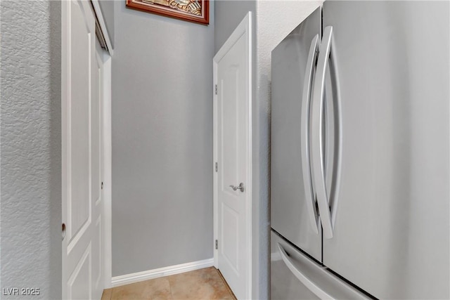 corridor with light tile patterned flooring and baseboards