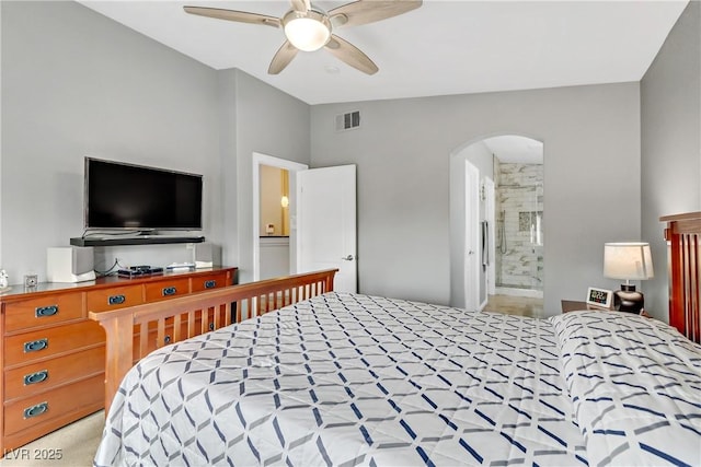 bedroom featuring visible vents, arched walkways, connected bathroom, lofted ceiling, and ceiling fan