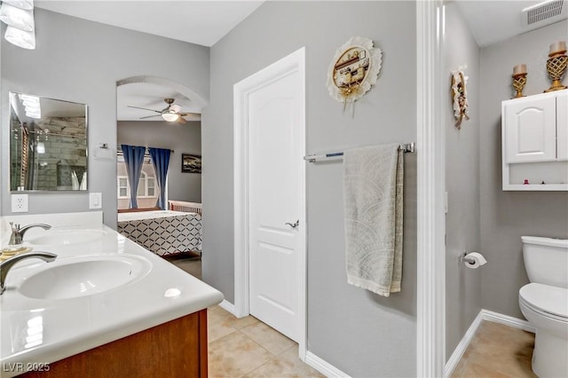 bathroom with toilet, a sink, visible vents, a ceiling fan, and a stall shower