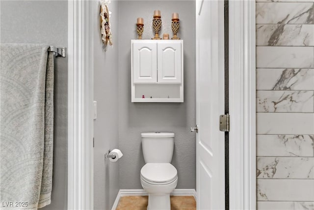 bathroom with toilet and baseboards