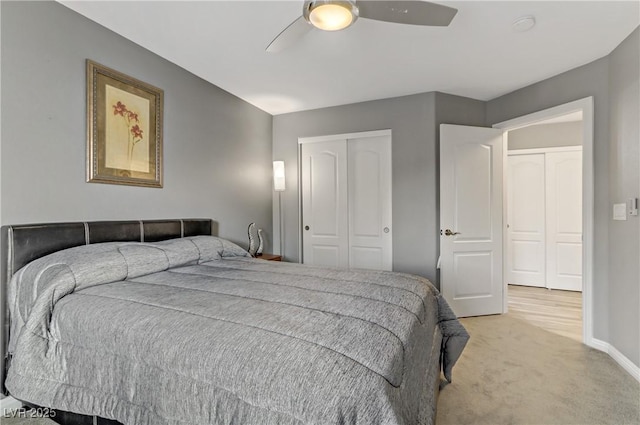 bedroom with a ceiling fan, a closet, light carpet, and baseboards