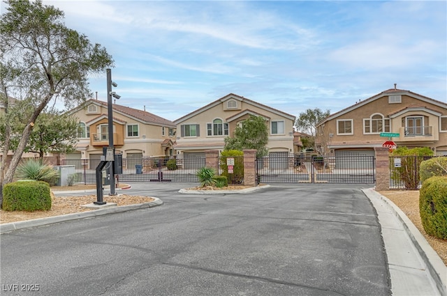 view of road with traffic signs, a gate, a gated entry, a residential view, and curbs