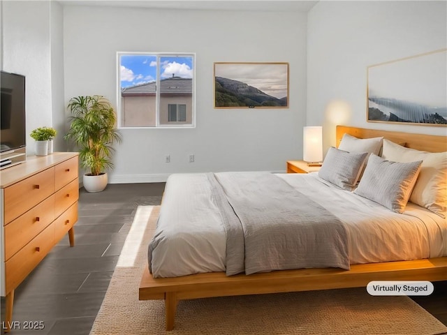 bedroom featuring baseboards and dark wood-style floors