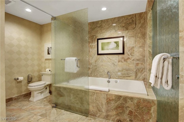 full bath featuring toilet, a tub to relax in, tile walls, and recessed lighting