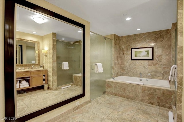 bathroom featuring a stall shower, a garden tub, tile walls, and vanity