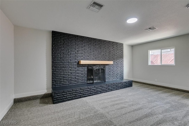 unfurnished living room with visible vents, baseboards, a textured ceiling, and a brick fireplace