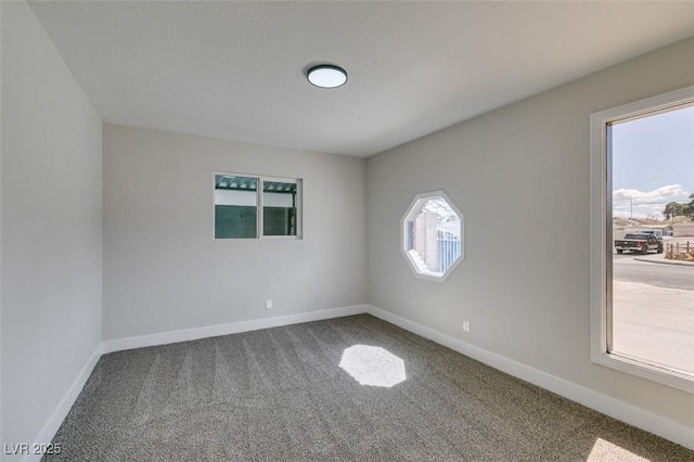 carpeted empty room with baseboards