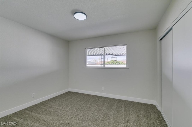 unfurnished bedroom featuring a closet, dark carpet, and baseboards