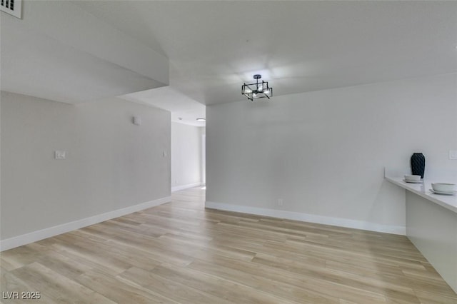 unfurnished dining area featuring visible vents, baseboards, and light wood-style floors