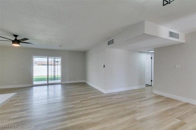 interior space with visible vents, baseboards, light wood-style floors, and a ceiling fan