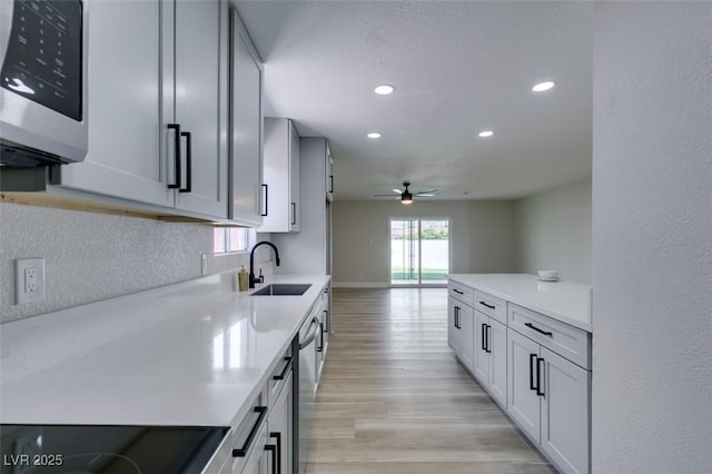 kitchen featuring recessed lighting, appliances with stainless steel finishes, light countertops, and a sink