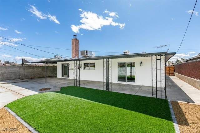 rear view of house with a patio area, central AC unit, a yard, and a fenced backyard