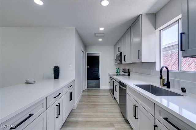 kitchen featuring visible vents, recessed lighting, stainless steel appliances, a sink, and light countertops